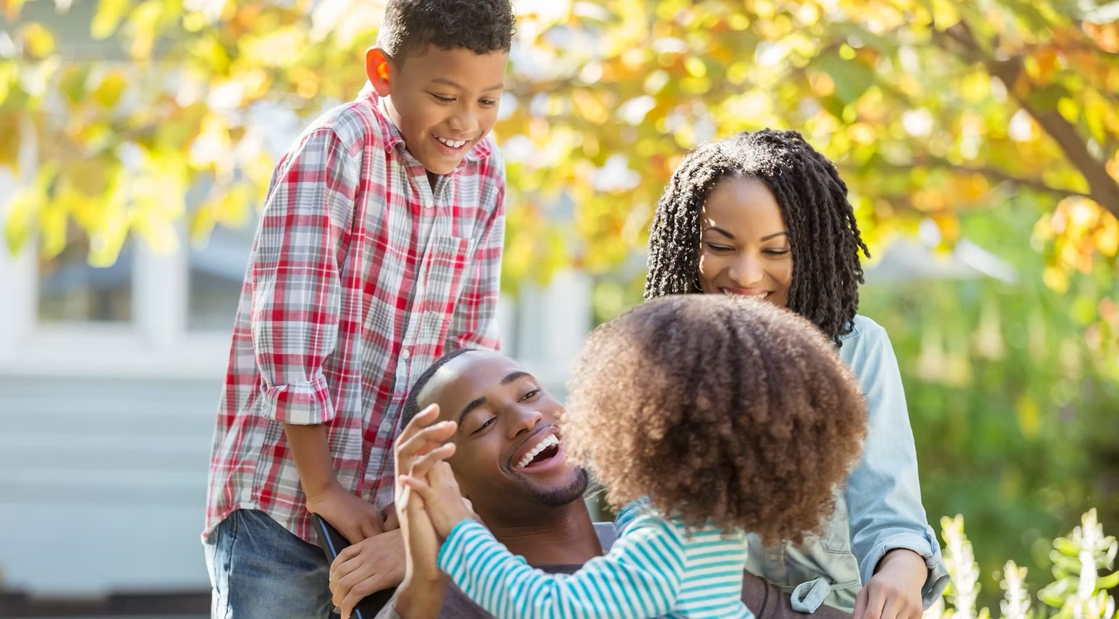 Parents laughing outdoors with their two young children